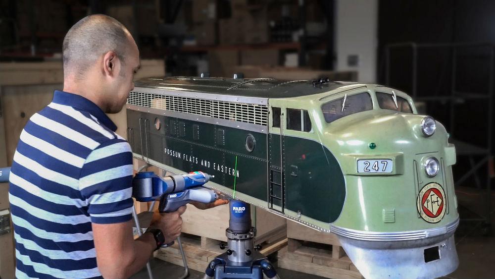 Engineer 3D scanning a scale model train